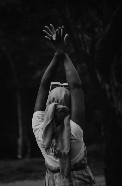 Silhouette of a person in a peaceful yoga pose against a bordeaux colored background.
